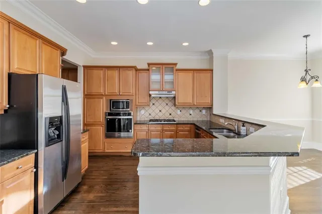 a kitchen with kitchen island a counter top space stainless steel appliances and cabinets