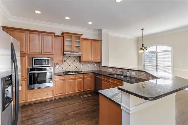 a kitchen with kitchen island granite countertop a stove a sink and a refrigerator