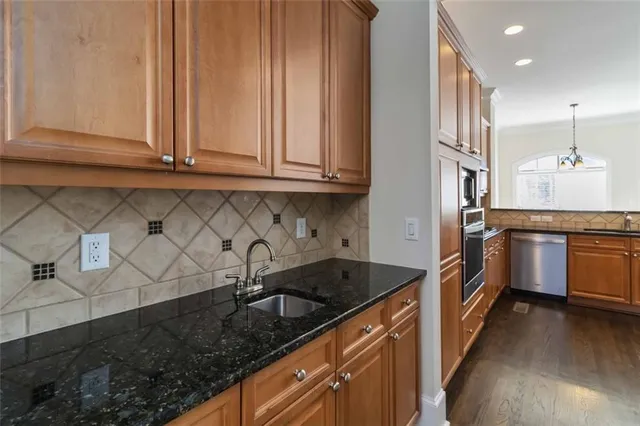a kitchen with granite countertop a sink and stainless steel appliances