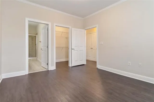 an empty room with wooden floor & closet and windows