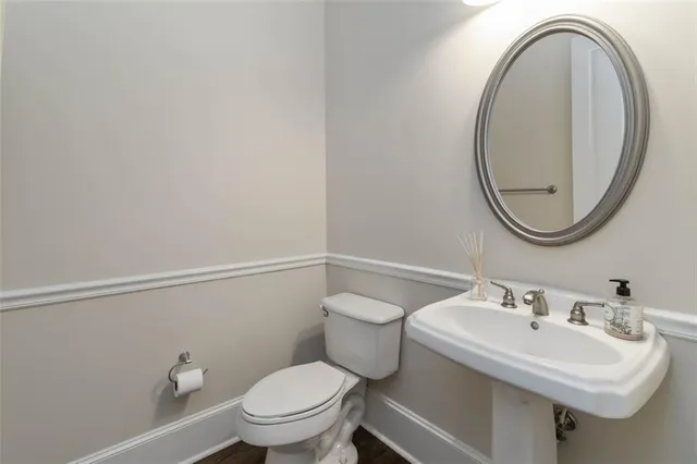 a bathroom with a sink a toilet and a mirror