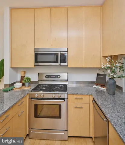 a kitchen with granite countertop cabinets stainless steel appliances and a sink