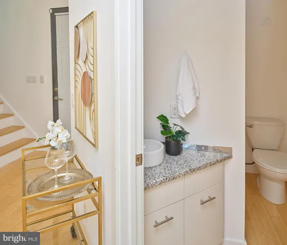 a bathroom with a granite countertop sink a toilet and mirror