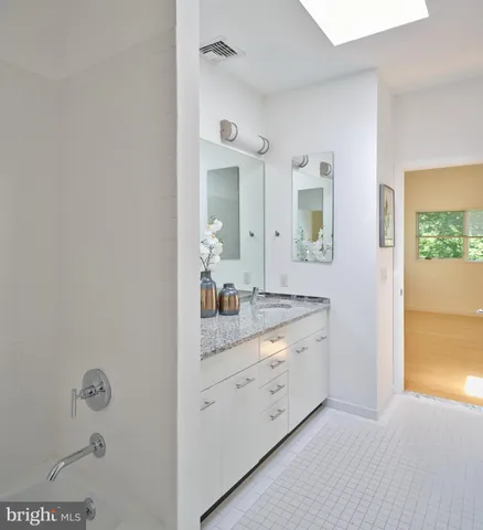 a bathroom with a granite countertop sink mirror and