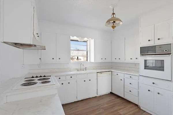 a kitchen with granite countertop white cabinets and white appliances