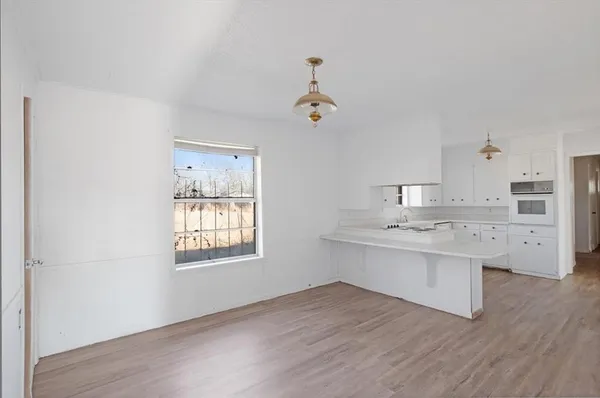 a kitchen with stainless steel appliances granite countertop a sink cabinets and wooden floor