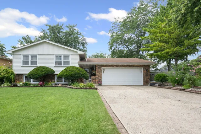 a view of a house with a yard and large trees