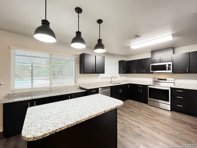 a kitchen with a center island and cabinets
