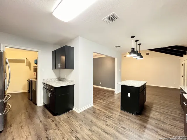 a view of kitchen with sink and refrigerator