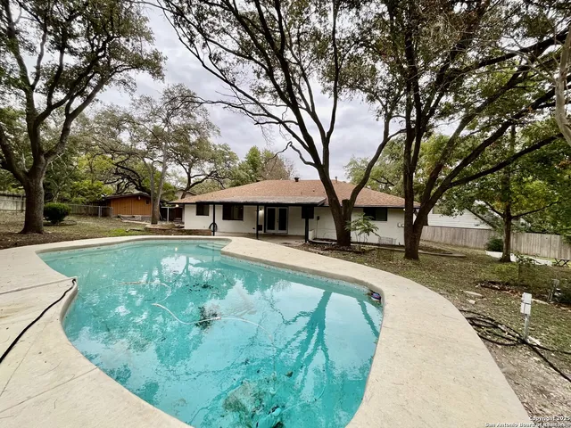 a view of backyard with swimming pool