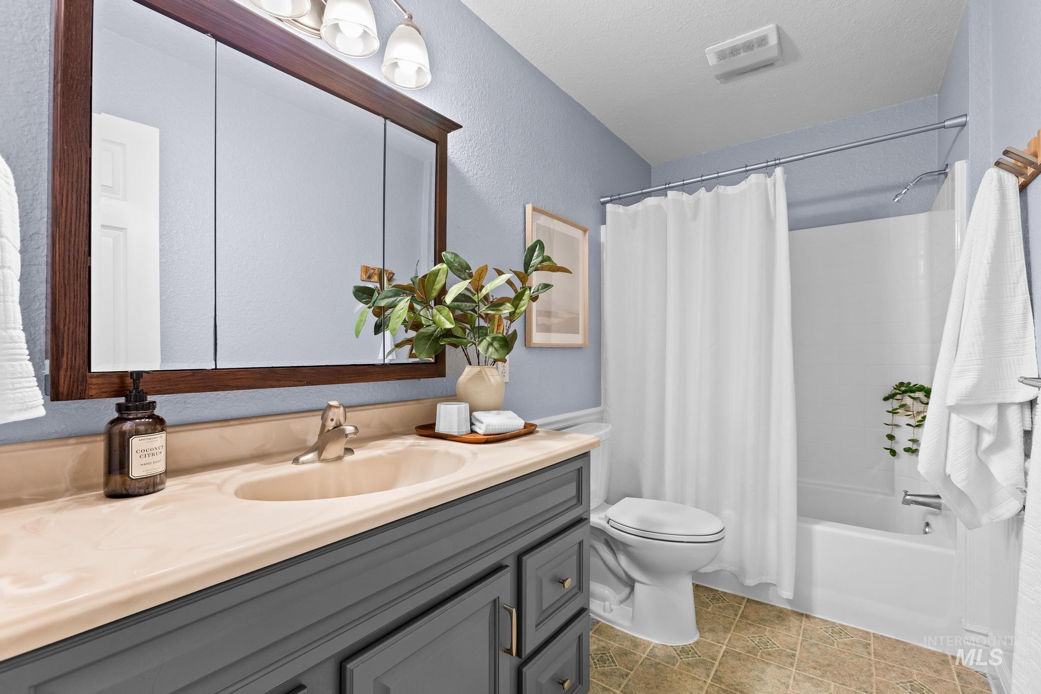 7514 West Swift Lane Boise, ID 83704 - Photo 22 of 46 Full bath featuring shower / bath combo with shower curtain, vanity, and a textured wall