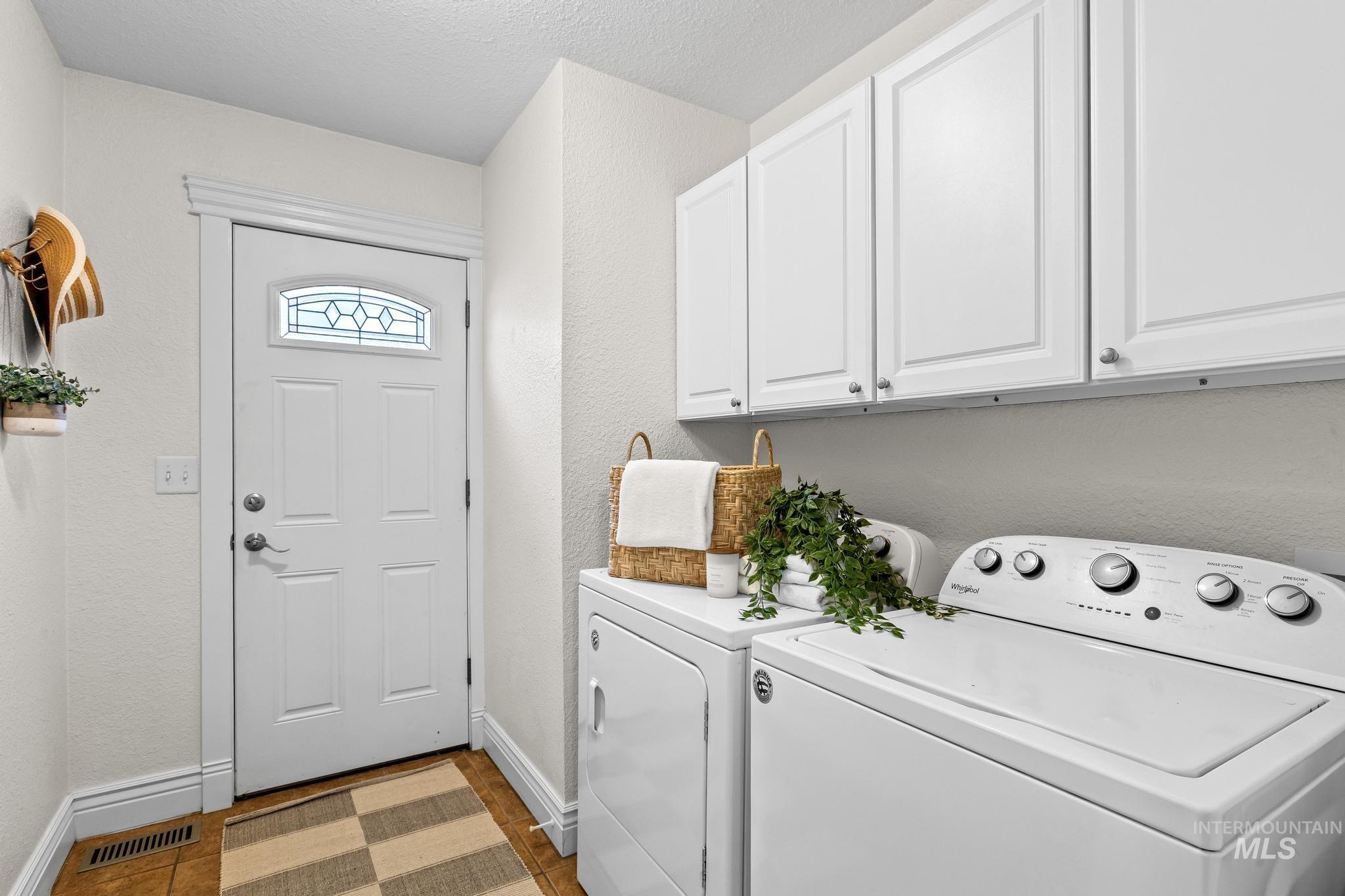 7514 West Swift Lane Boise, ID 83704 - Photo 23 of 46 Laundry room with a textured wall, cabinet space, washer and dryer, and a textured ceiling