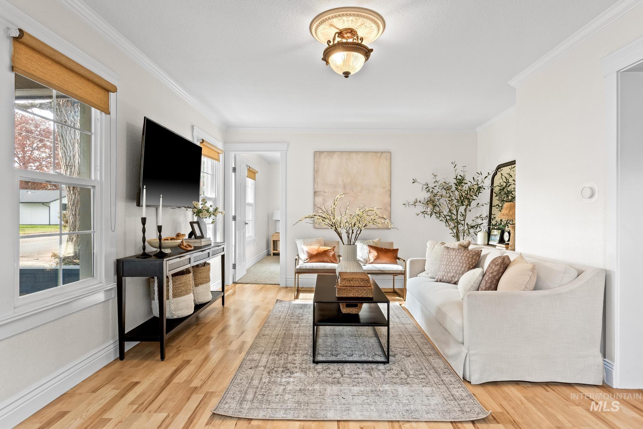 7514 West Swift Lane Boise, ID 83704 - Photo 5 of 46 Living area featuring light wood finished floors, ornamental molding, and plenty of natural light