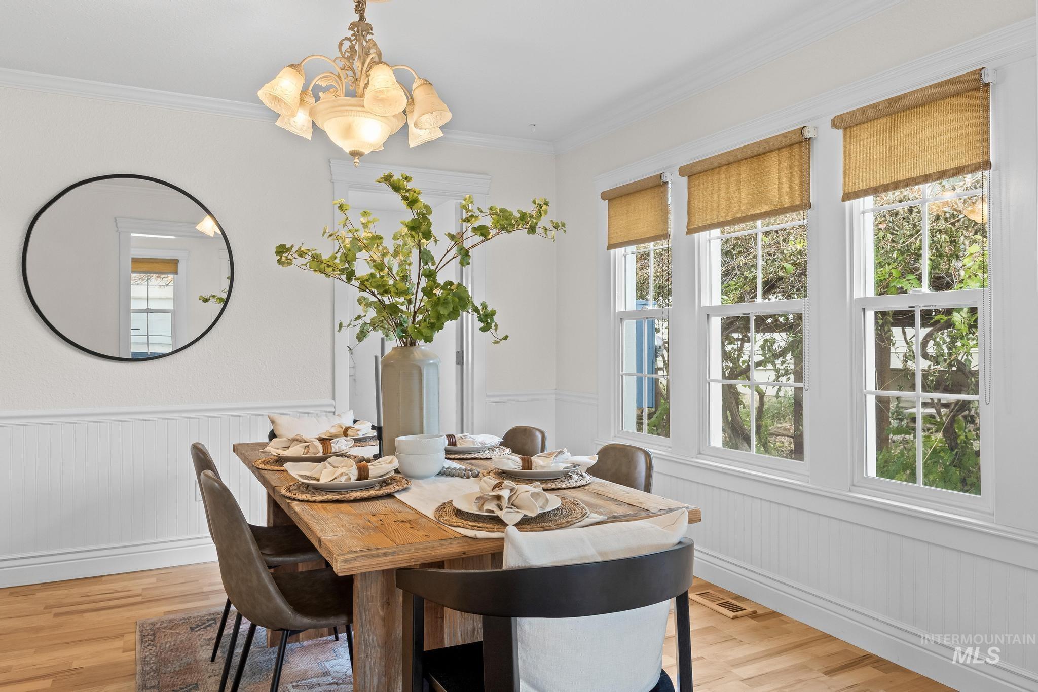 7514 West Swift Lane Boise, ID 83704 - Photo 9 of 46 Dining room featuring wainscoting, light wood-type flooring, crown molding, and a chandelier