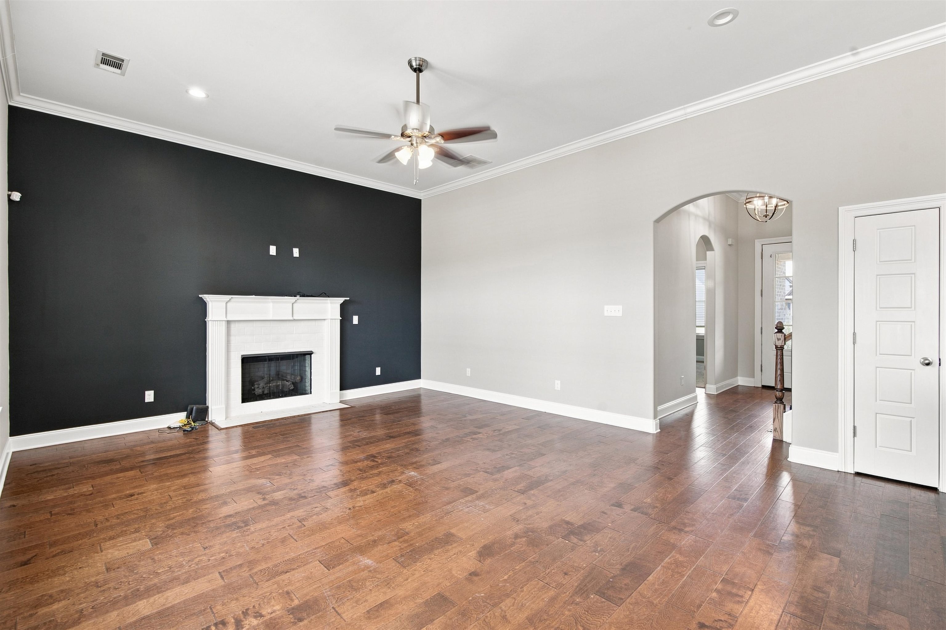 70 Trinity Cove Atoka, TN 38004 - Photo 6 of 19 Hardwood-finish flooring, vaulted ceiling with recessed lighting, ceiling fan, decorative fireplace with mantel, and arched entryway