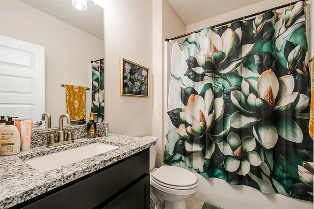 a bathroom with a granite countertop sink a toilet and a mirror