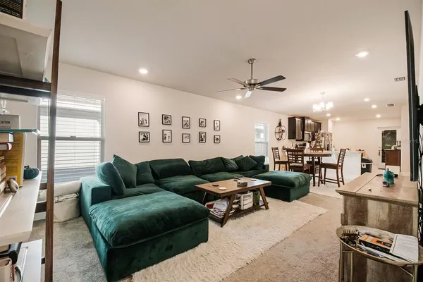 a living room with furniture kitchen view and a flat screen tv