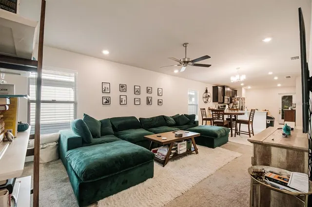 a living room with furniture kitchen view and a flat screen tv
