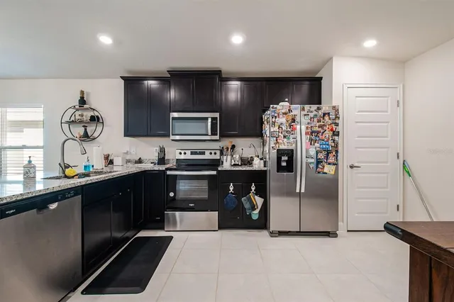 a kitchen with stainless steel appliances a refrigerator sink and stove