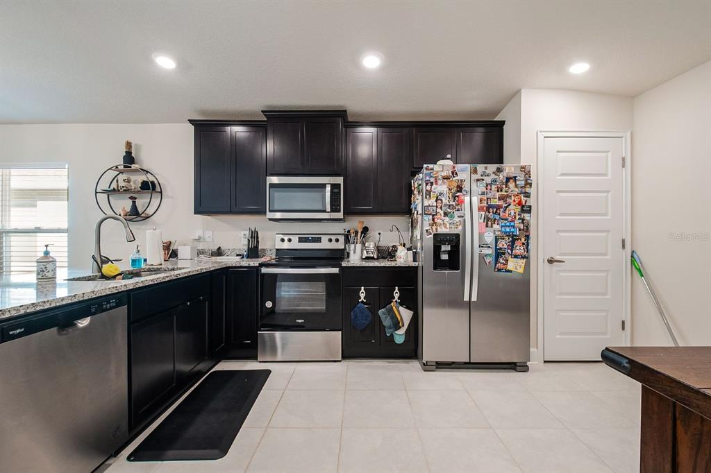 3711 Sagefield Drive Harmony, FL 34773 - Photo 7 of 18 a kitchen with stainless steel appliances a refrigerator sink and stove