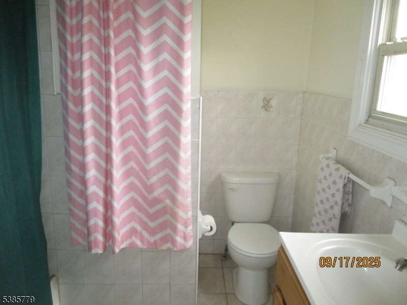 7 Kossuth Street Newark, NJ 07105 - Photo 14 of 18 a white toilet sitting next to a shower curtain