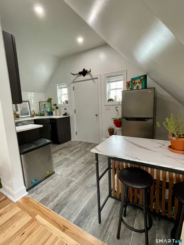 a kitchen with granite countertop a table chairs stove and cabinets