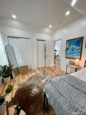 a bedroom with a bed a chair and painting on the wall