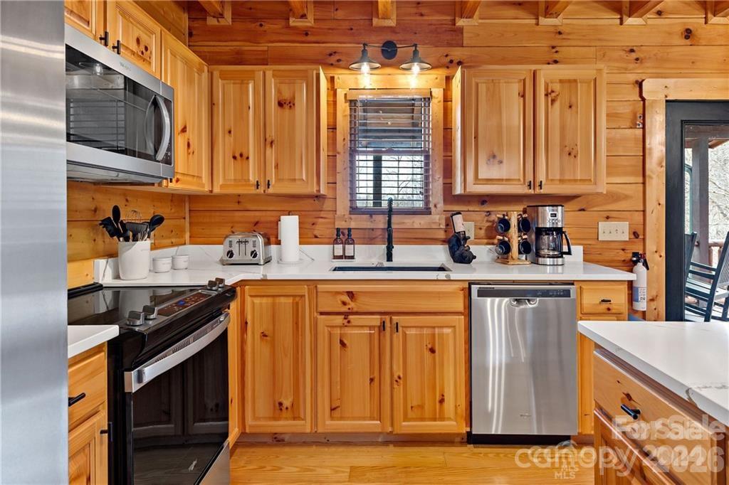 552 Lake Road Old Fort, NC 28762 - Photo 13 of 46 a kitchen with stainless steel appliances granite countertop a stove a sink and a microwave