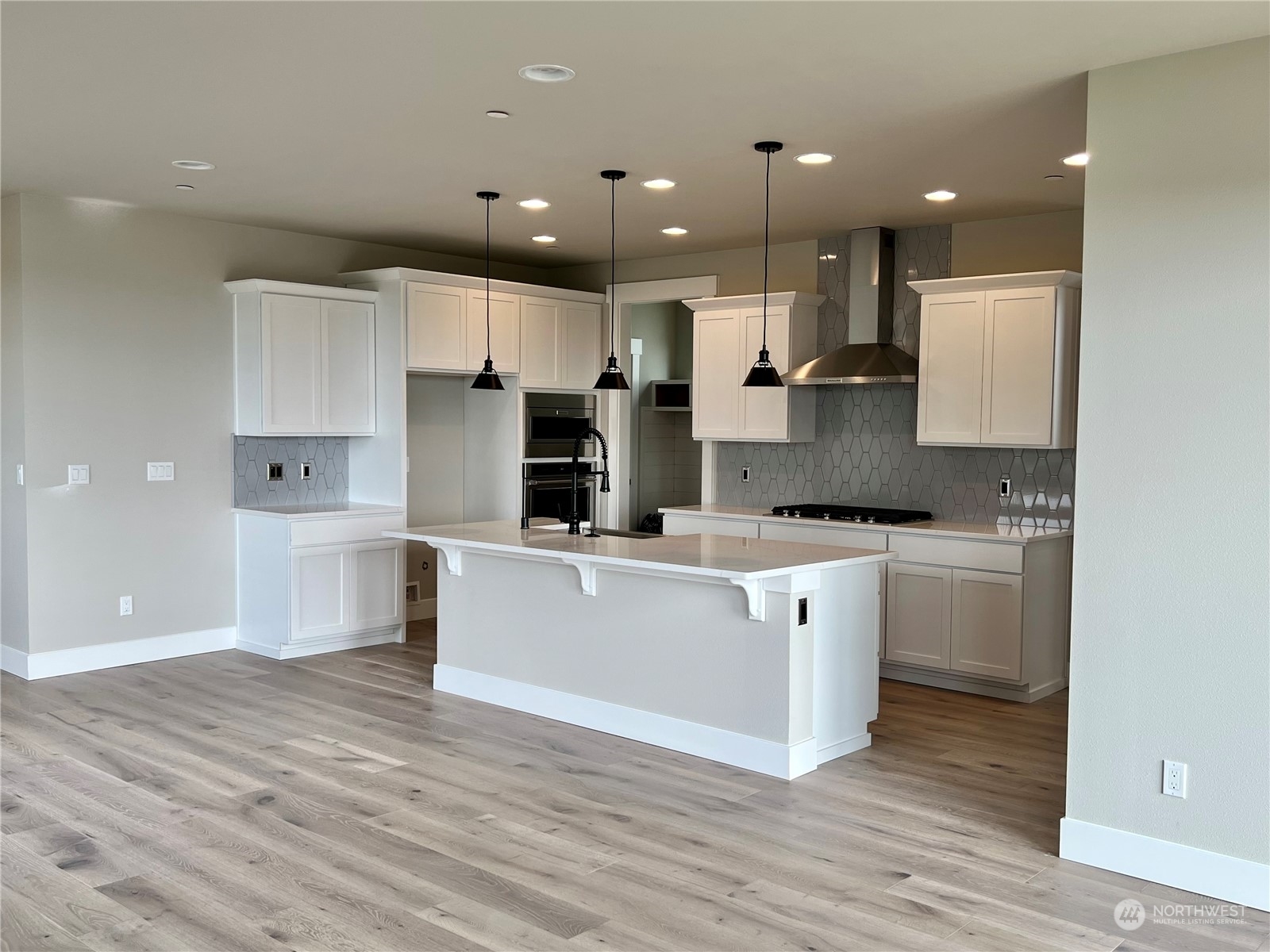 4324 243rd Place Southeast, Unit LOT47 Bothell, WA 98021 - Photo 4 of 39 a large kitchen with stainless steel appliances a large counter top a stove a sink and a refrigerator