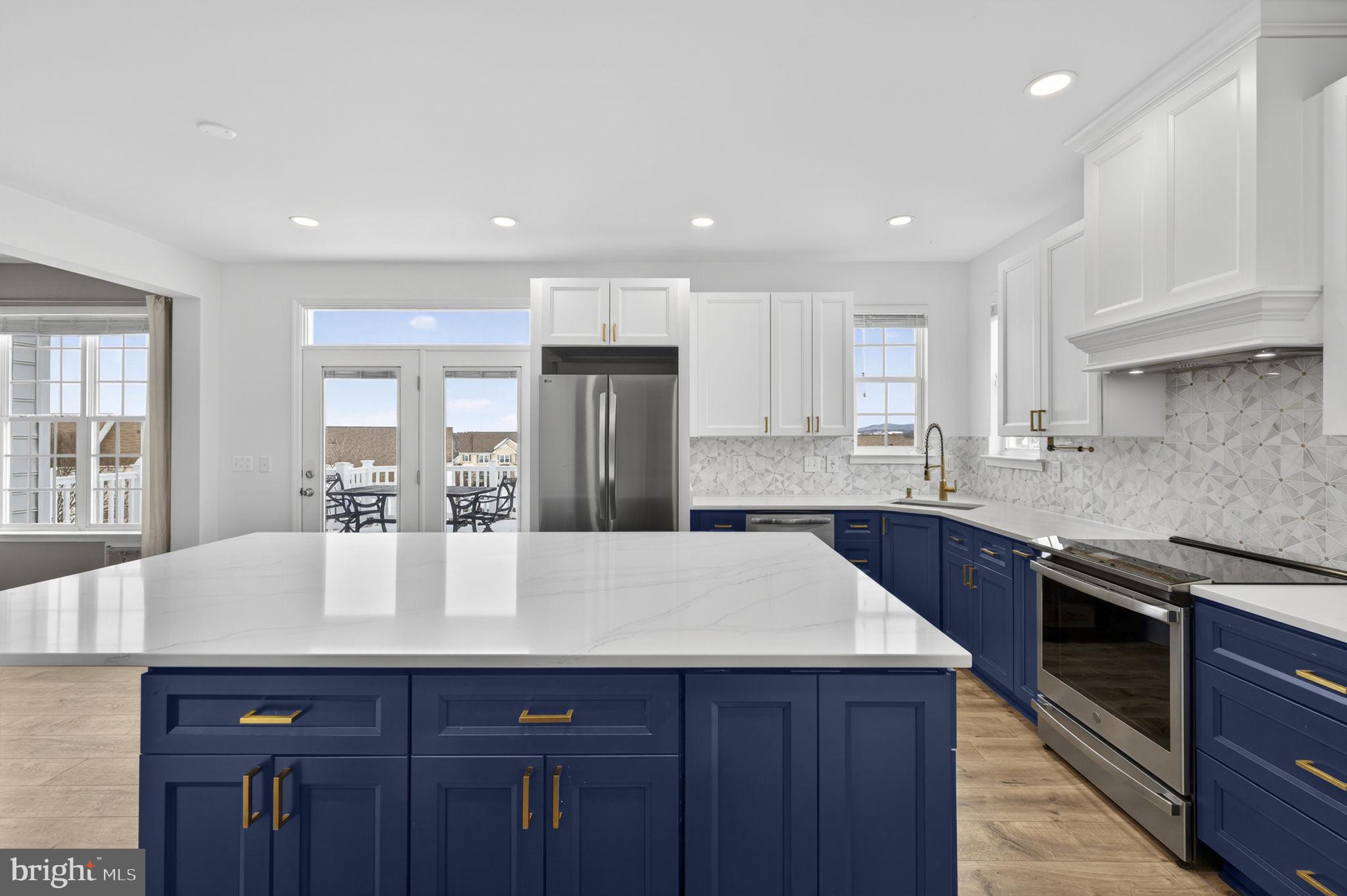 43132 Butterfly Way Leesburg, VA 20176 - Photo 9 of 63 a large kitchen with granite countertop a center island stainless steel appliances and cabinets