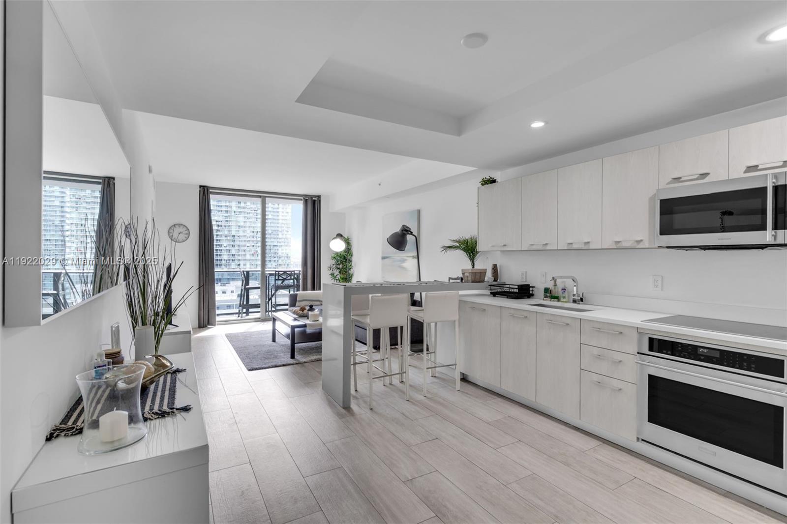 55 Southwest 9th Street, Unit 1705 Miami, FL 33130 - Photo 3 of 28 a kitchen with sink stove and cabinets