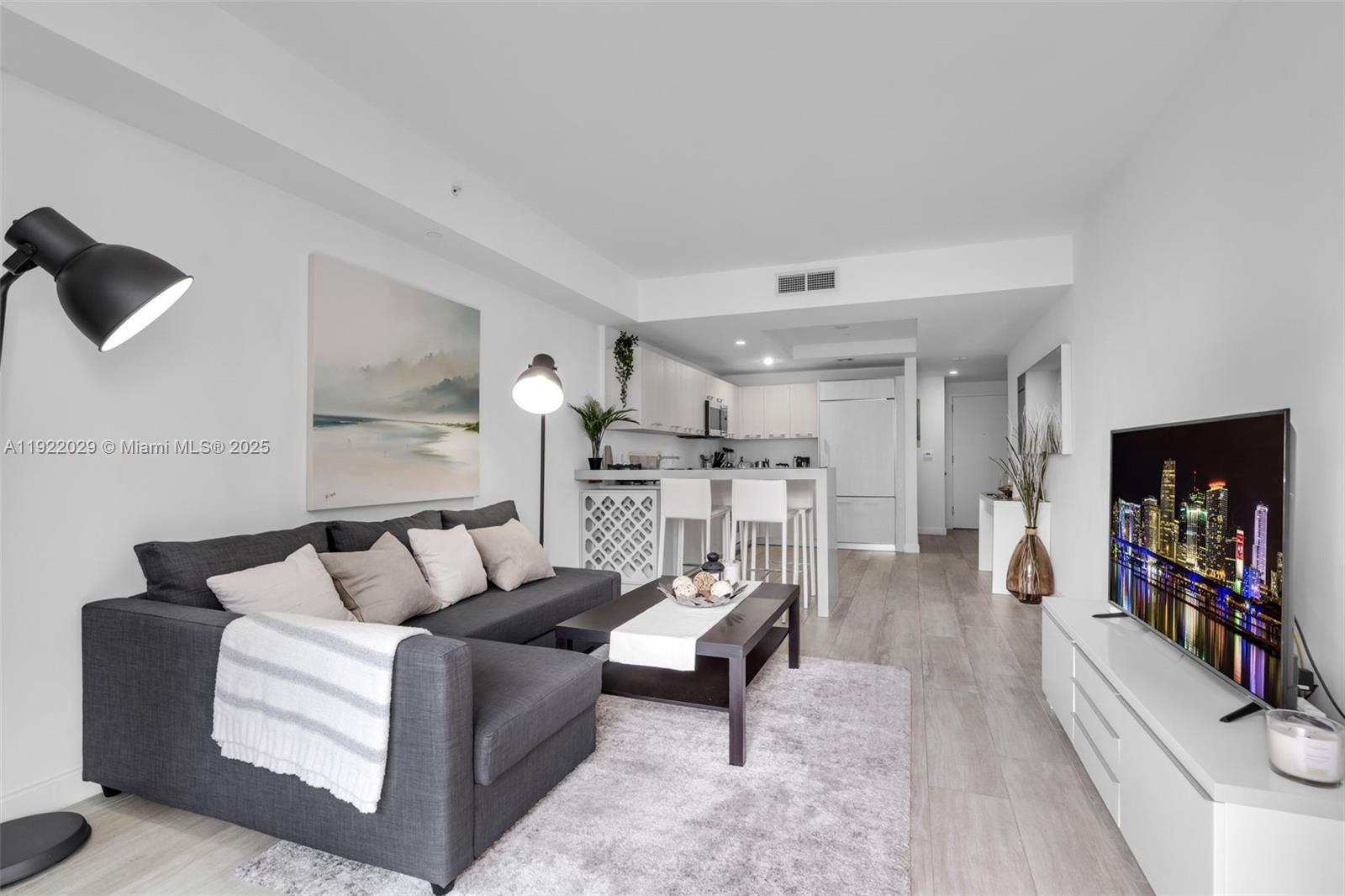 55 Southwest 9th Street, Unit 1705 Miami, FL 33130 - Photo 6 of 28 a living room with furniture and a flat screen tv