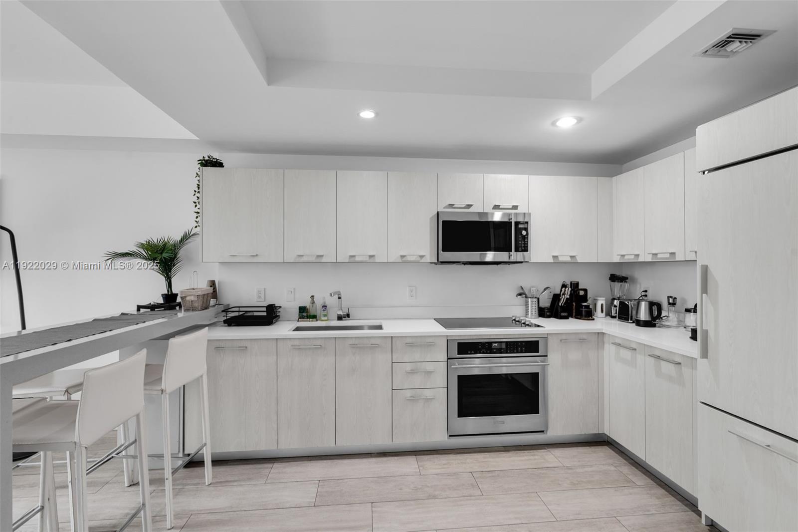 55 Southwest 9th Street, Unit 1705 Miami, FL 33130 - Photo 8 of 28 a kitchen with granite countertop white cabinets and white appliances