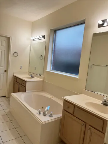 a bathroom with a tub sink and mirror