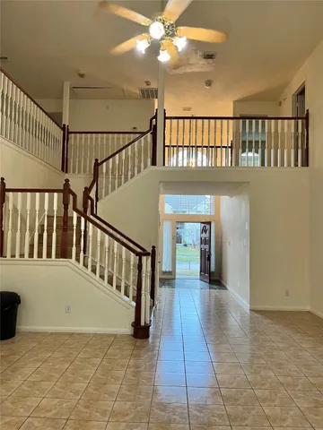 a view of staircase with railing and a chandelier