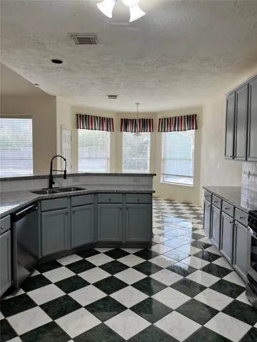 a kitchen with a checkered floor and white cabinets