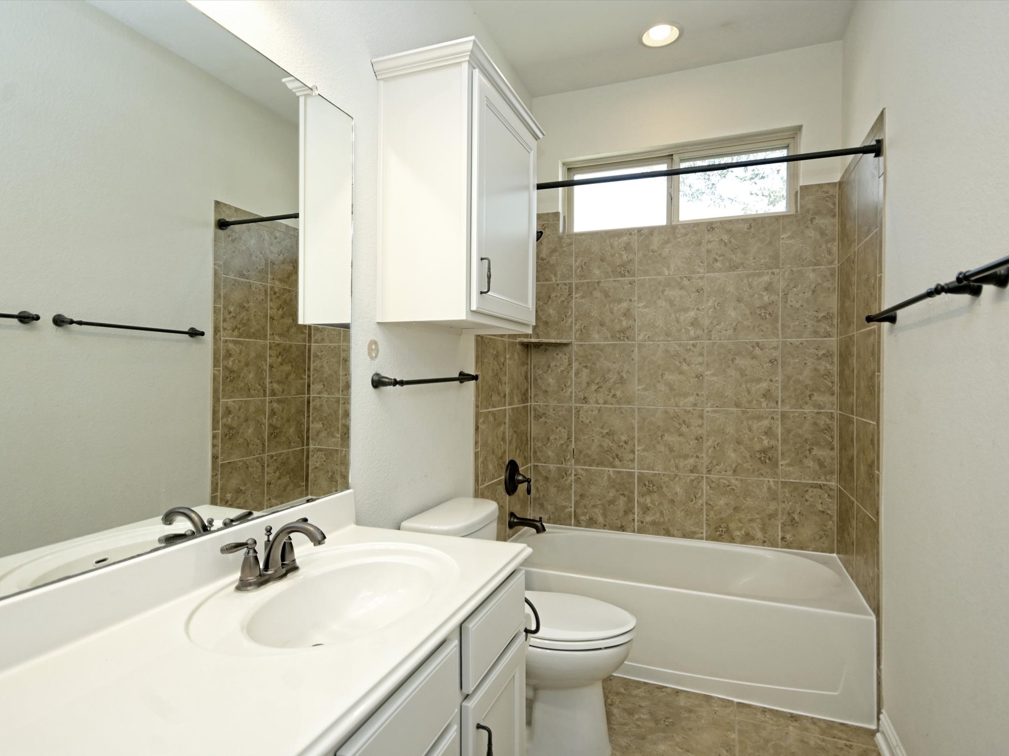 201 Bellagio Drive Austin, TX 78734 - Photo 22 of 31 The main floor guest bathroom includes a spacious vanity and shower/tub combo with tiled backsplash.