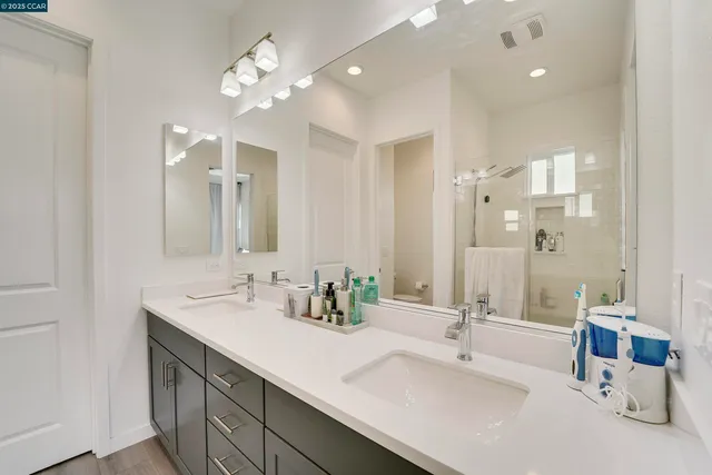 a bedroom with a bed a flat screen tv and a chandelier