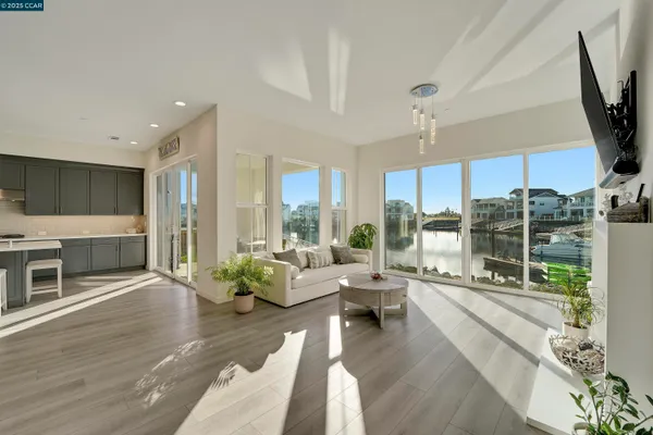 a living room with couches a coffee table and chairs with wooden floor