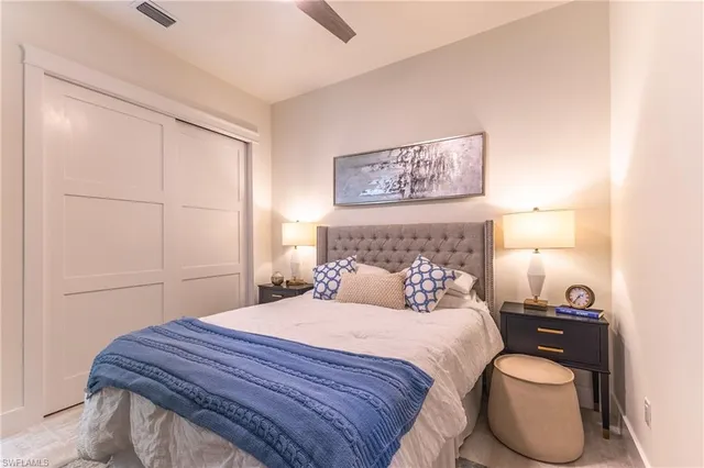 a bedroom with a bed a couch and a chandelier fan