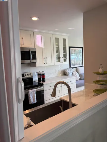 a kitchen with a sink and a stove top oven with wooden floor