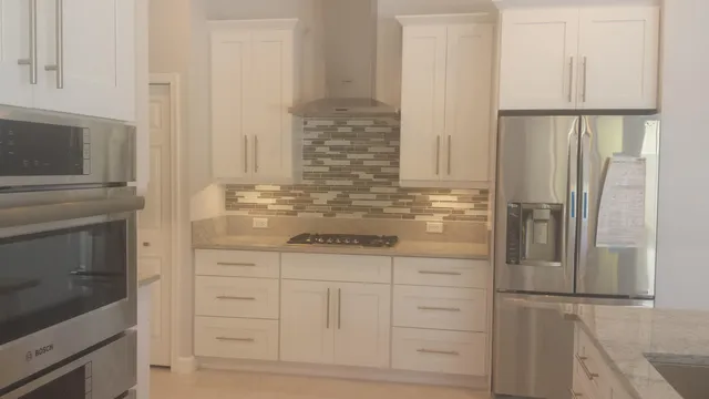 a bathroom with white cabinets and a sink