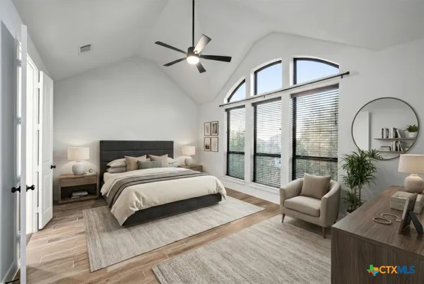 a spacious bedroom with a bed couch and a window