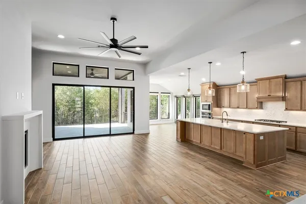 a large kitchen with granite countertop a large counter top space appliances and cabinets