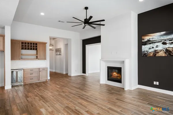 a view of a kitchen with a sink a fireplace and wooden floor