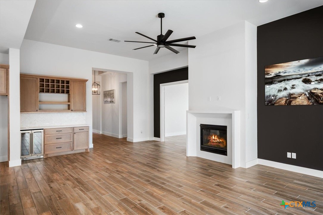 412 Pin Cherry Pass San Marcos, TX 78666 - Photo 5 of 27 a view of a kitchen with a sink a fireplace and wooden floor