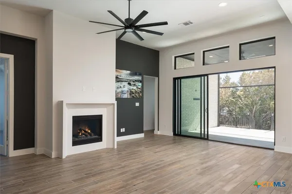 a view of an empty room with a fireplace and a window