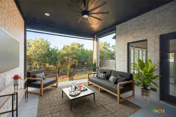 a living room with patio furniture and a potted plant