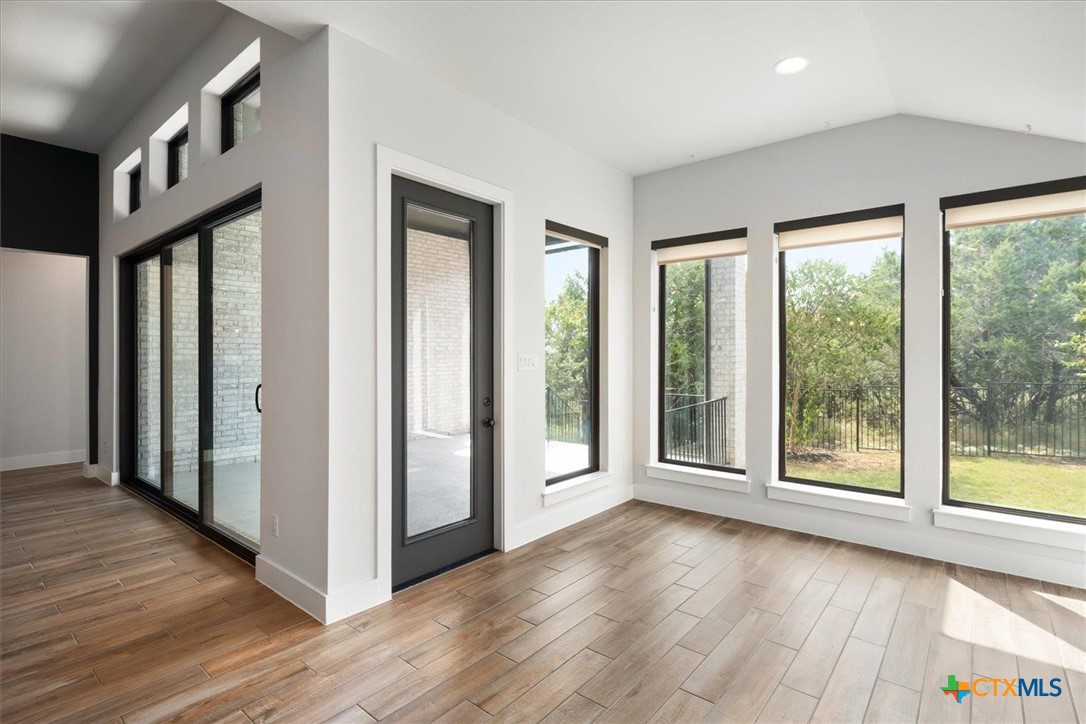412 Pin Cherry Pass San Marcos, TX 78666 - Photo 9 of 27 a view of an empty room with wooden floor and a window