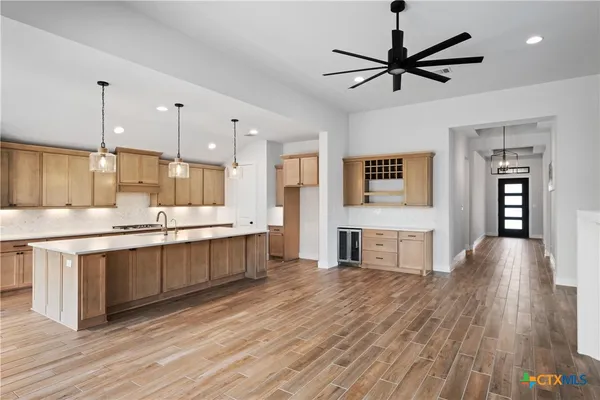 a large kitchen with cabinets wooden floor and stainless steel appliances